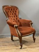 A Victorian walnut armchair, arched top over button-back, upholstered in burnt orange velvet fabric,