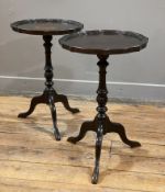 A pair of reproduction tripod wine tables, pie-crust edges and raised on baluster support, on