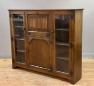 An Arts and Crafts oak bureau bookcase, central panel with carved fall-front revealing writing