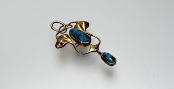 An Edwardian Art Nouveau 9ct gold pendant set with an oval turquoise central panel within a