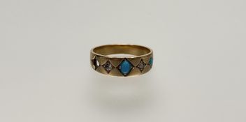 An Edwardian yellow metal ring set two graduated turquoise cabochons, interspaced with rose cut