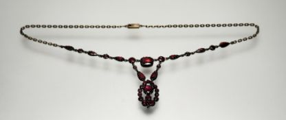 An Edwardian 9ct gold red facet cut stone mounted pendant necklace in foil-backed setting on a fixed