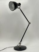 A modern Anglepoise table lamp in black, with chrome mounts and raised on a circular base (h.