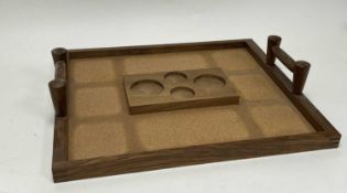A twin-handled wooden tray with cork base and central raised platform with fitted circles (l. 47.