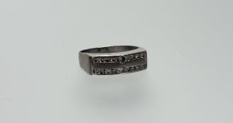 A platinum ring set two rows of nine brilliant cut diamonds the centre larger stones 0.05ct Q/R
