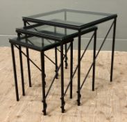 A set of three wrought iron nesting tables, of modernist form with glass tops on tubular supports