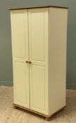A modern pine double wardrobe, with cream-painted twin panel doors enclosing shelf and hanging