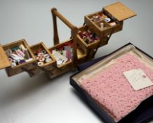 A wooden extending three tiered sewing basket containing various threads and buttons etc, together