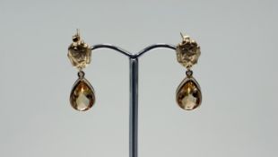 A modern pair of 9ct gold drop earrings with flower cast mount and pear shaped citrine faceted