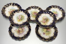 A set of seven Doulton Burslem scallop edged plates each decorated with different flowers to