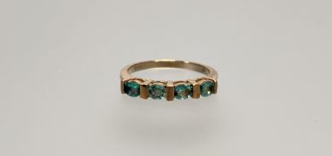 A modern 9ct gold ring set set four green round facet cut stones O 2.83g