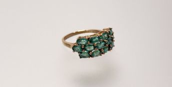 A modern 9ct gold ring set thirteen green oval facet cut stones O 3.2g