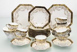 A 19thc Wedgwood part tea service in a hand-painted golden foliate swags within a gilt and black