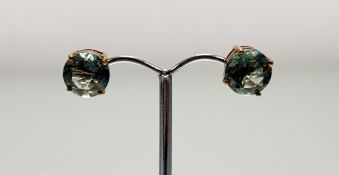A pair of 9ct green stone set stud earrings: d. x 0.5cm 4g
