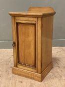 An Edwardian oak bedside cabinet, ledge back over inset cupboard door, enclosing shelf to