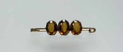 An Edwardian yellow metal bar brooch set three oval citrine coloured stones: l. x 5cm 6.42g