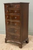 A reproduction mahogany chest of drawers, bow front with six graduated drawers to front, raised on