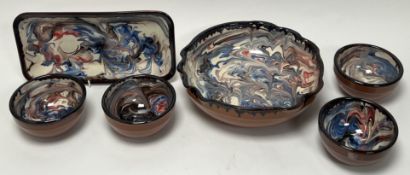 A collection of Sanish terracotta dishes by 'Naturally Med', all decorated with white marbeled