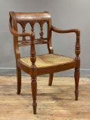 A Regency-style cherrywood armchair, carved splat back and shaped arms, over a rattan seat and