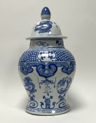 A 20th Century Chinese blue and white urn and cover, decorated with dragons, scrolls, and foliate