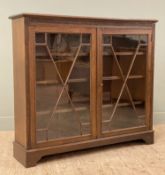 An Edwardian oak bookcase by Maple & Co, carved lattice frieze over twin astragal glazed doors