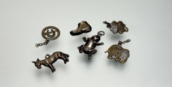 A collection of misc silver metal charms comprising, an elephant, a frog, a four leaf clover, a