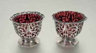 A pair of Victorian London silver octagonal scalloped pierced salts with original cranberry glass