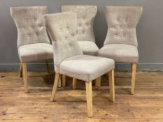 A set of four modern dining chairs, curved button-backs upholstered in grey fabric raised on tapered