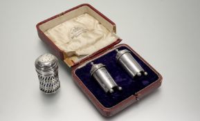A pair of Chetser silver cylinder pepperettes with domed covers and urn finials, and original blue
