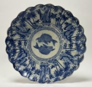 An early 20thc Japanese blue and white charger of scalloped form, decorated to the centre with