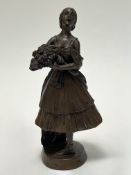 A bronze figure of a dancer holding a bunch of roses, raised on a circular base (h. 17cm)