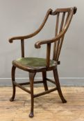 An Edwardian mahogany carver chair, open arms and three-slat back, over green seat raised on