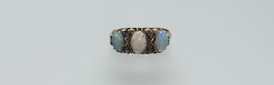 An 18ct gold three stone fire opal ring each opal approximately 0.35ct with a pair of rose cut