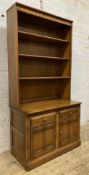 An Ercol Golden Dawn elm bookcase, moulded cornice over three adjustable shelves to front, on a base