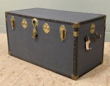 A vintage steamer trunk, brass-mounted with studded detail to sides, enclosing lined interior (one
