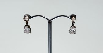 A pair of yellow metal mounted drop earrings with a seed pearl mount and pear shaped clear stone