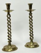 A pair of twisted brass stem candlesticks raised on circular bases with circular drip trays (h.