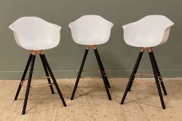 A set of three modern breakfast bar stools, with white bucket seats raised on turned wood supports