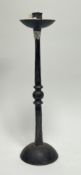 A wrought iron single candlestick with knopped stem and raised on a domed circular base (h. 40)
