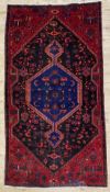 A hand-knotted Persian Zanjan rug, large central medallion with stylized tribal motifs, indigo and