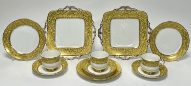 A Paragon part tea service with gilt foliate decoration on a yellow ground, comprising three tea