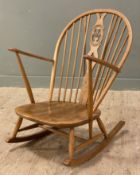 An Ercol Model 316 elm rocking chair, arched top and spindle back, with a saddle seat raised on