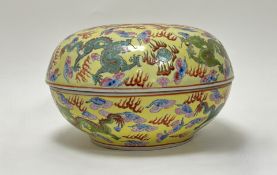 An early 20thc Chinese Famille Rose oval dish and cover, enamelled with dragons chasing the pearl on