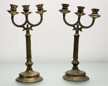 A pair of brass metal three branch corthian column candlestick holders, raised on ciruclar base. (