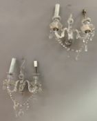 A pair of 20th century cut and moulded glass wall lights, each with two branches and crystal
