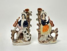 A pair of 19thc Staffordshire flatback spill vases depicting a couple, both holding lutes: the man