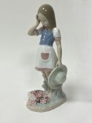 A Lladro porcelain figure of 'Dropping The Flowers', modelled as a young girl standing above flowers