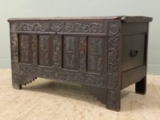 An 18th century oak coffer chest, dated 1796, plank top over four panel front, heavily carved with