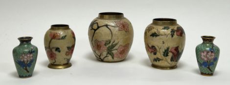 A graduated set of three Chinese brass ginger jars decorated in polychrome enamels on a tan