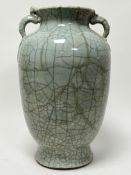 A Chinese celadon vase of bulbous form with twin serpent handles and crackle glaze decoration (a/f